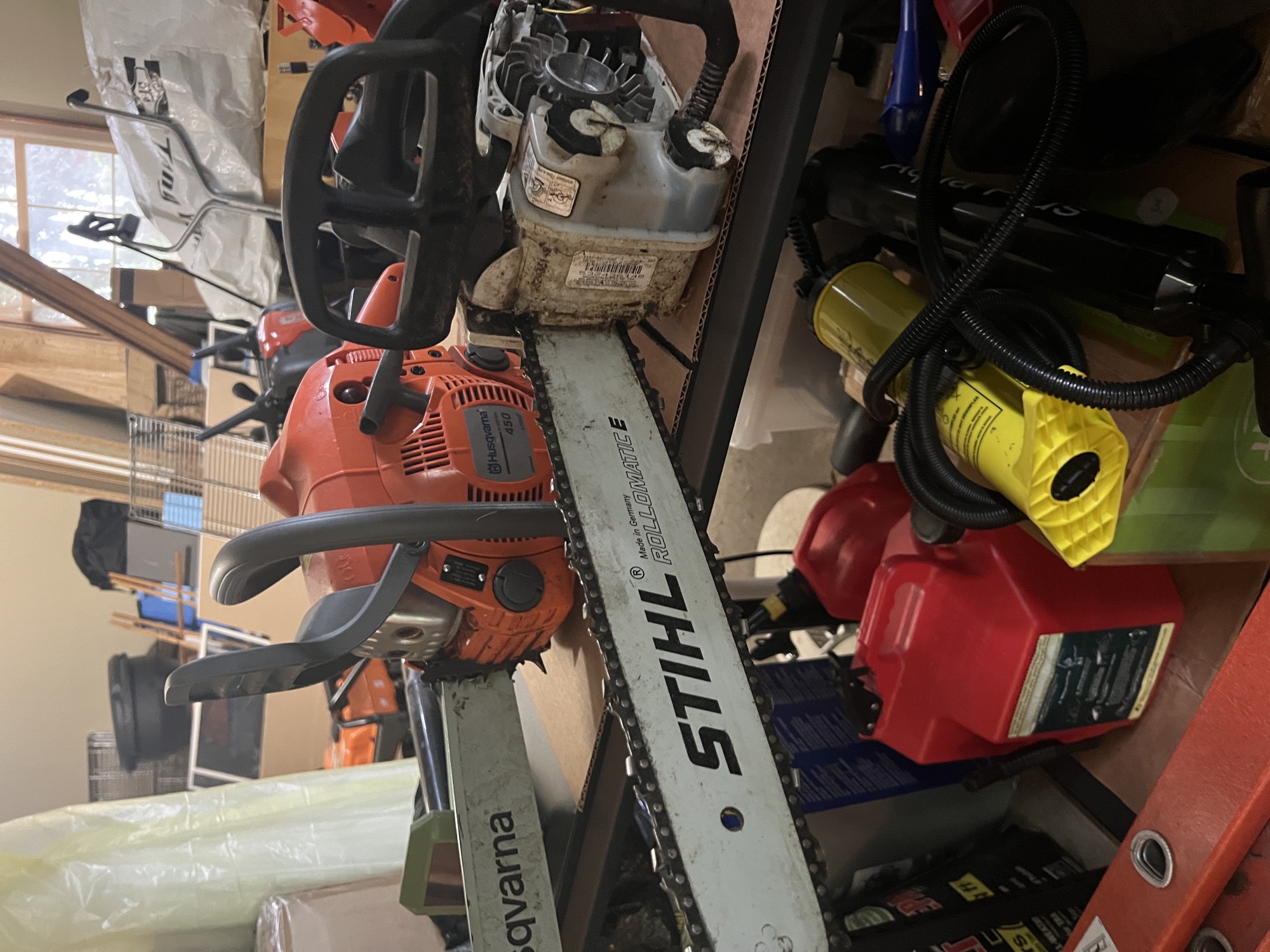 The Stihl MS 194 T top-handle saw stored alongside the Husqvarna 450 in the New Hope garage.