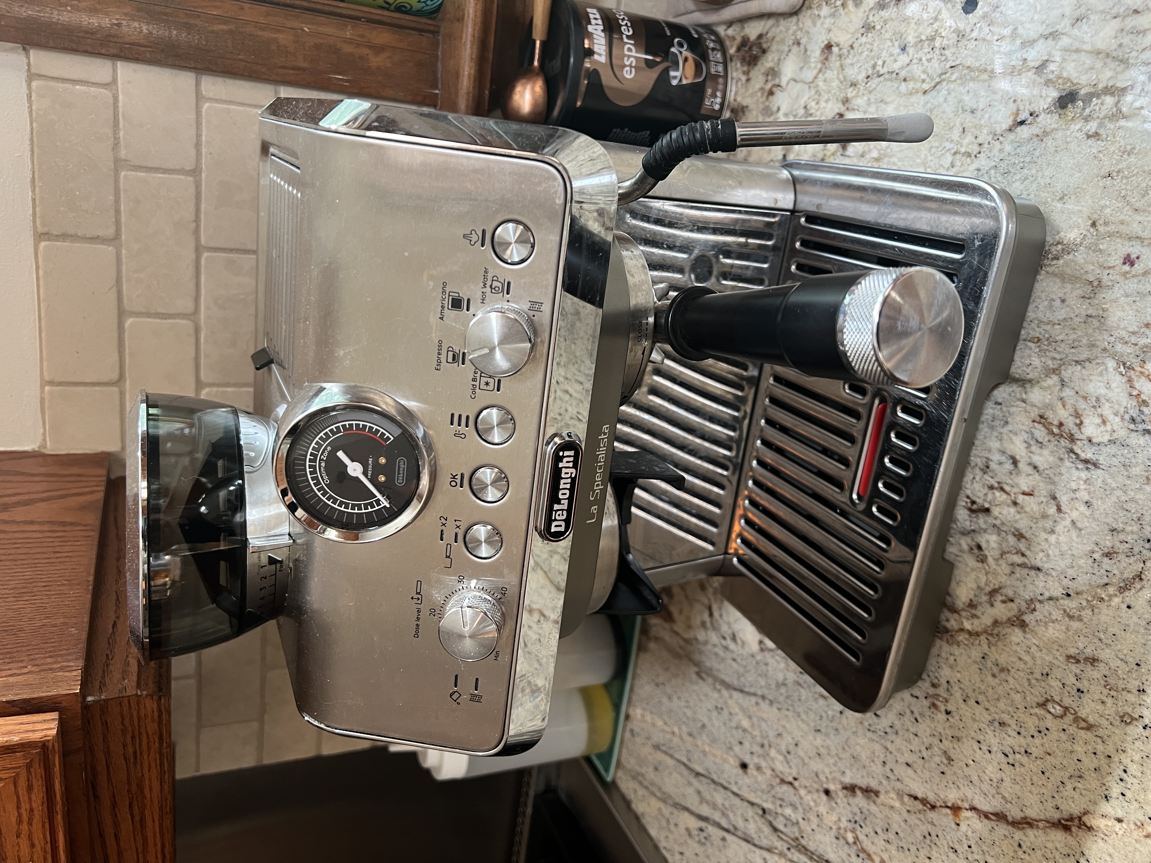 DeLonghi La Specialista Arte Evo EC9255M espresso machine on the New Hope kitchen counter. Stainless steel body with pressure gauge, mode dial (Espresso / Americano / Cold Brew / Hot Water), and conical burr grinder hopper visible.