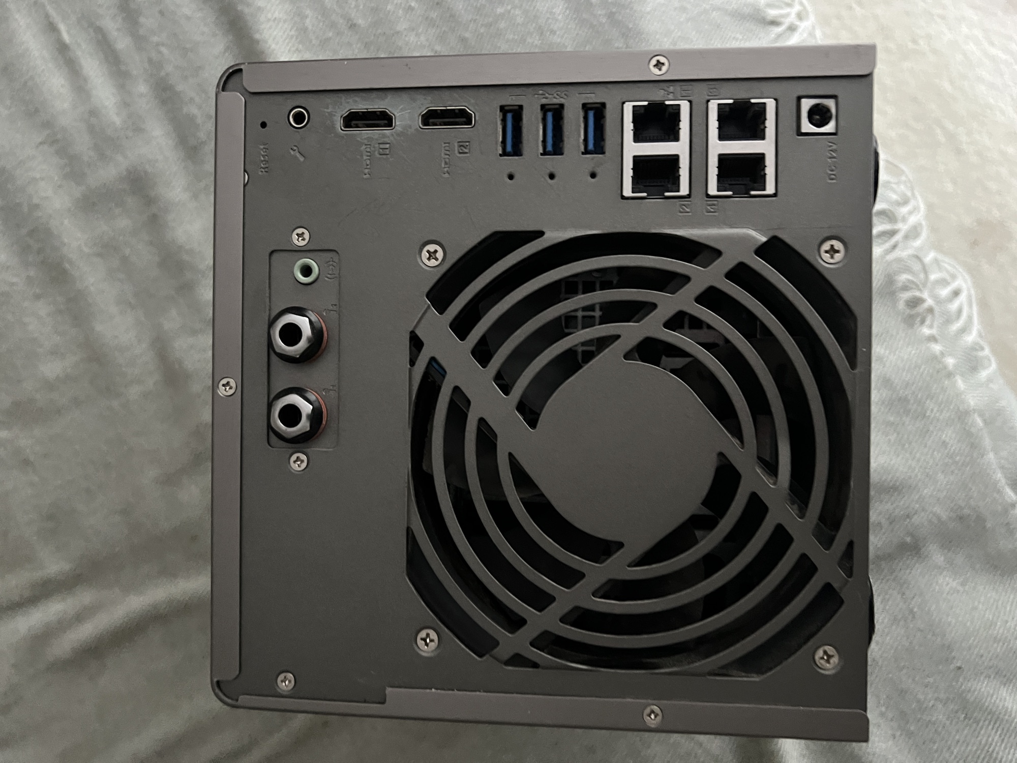 Rear panel of the QNAP TS-453A — single 120 mm cooling fan, two HDMI 1.4b 4K outputs, three USB 3.0 type-A ports, four Gigabit Ethernet RJ45 jacks for link aggregation, 3.5 mm audio in/out, and the 12 V DC power input.